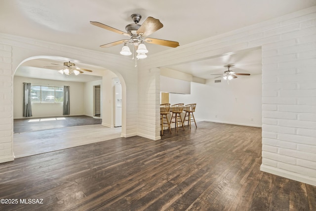 1716 S Sleepy Hollow Ave, Tucson, AZ 85710 - unfurnished living room featuring arched walkways, wood finished floors, and ceiling fan