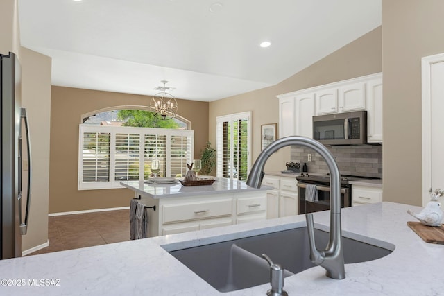 37358 S Ridgeview Blvd, Saddlebrooke, AZ 85739 - kitchen featuring stainless steel appliances, a sink, backsplash, light stone countertops, and plenty of natural light