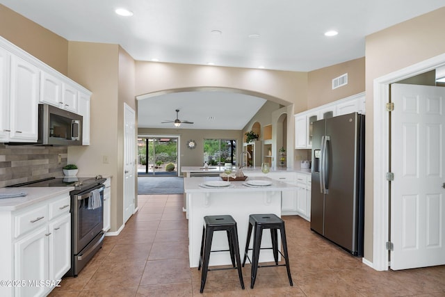 37358 S Ridgeview Blvd, Saddlebrooke, AZ 85739 - kitchen featuring appliances with stainless steel finishes, arched walkways, lofted ceiling, ceiling fan, and backsplash