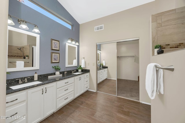 37358 S Ridgeview Blvd, Saddlebrooke, AZ 85739 - full bath with double vanity, a tile shower, wood finished floors, a spacious closet, and a towering ceiling