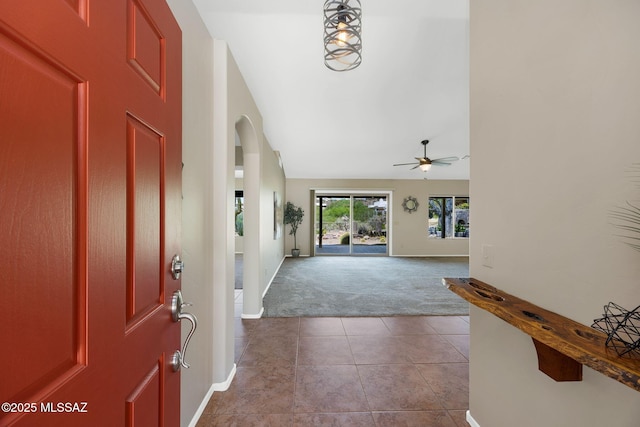 37358 S Ridgeview Blvd, Saddlebrooke, AZ 85739 - foyer entrance featuring carpet flooring, arched walkways, tile patterned flooring, vaulted ceiling, and baseboards