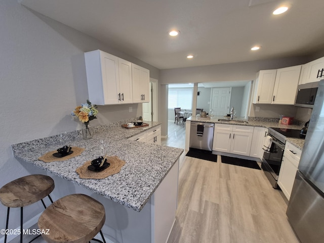 230 N Biddle Ave, Willcox, AZ 85643 - kitchen featuring appliances with stainless steel finishes, a peninsula, white cabinetry, light stone countertops, and recessed lighting