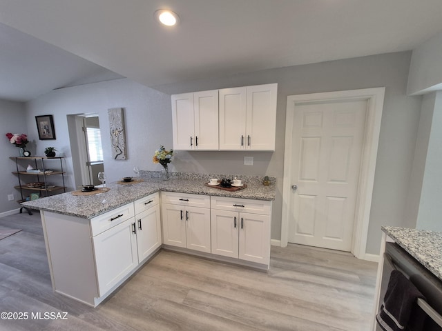 230 N Biddle Ave, Willcox, AZ 85643 - kitchen featuring a peninsula, white cabinetry, light stone countertops, and light wood-style flooring