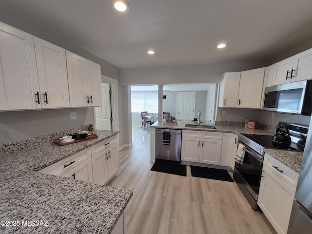 230 N Biddle Ave, Willcox, AZ 85643 - kitchen featuring appliances with stainless steel finishes, a sink, white cabinets, light wood-style floors, and recessed lighting