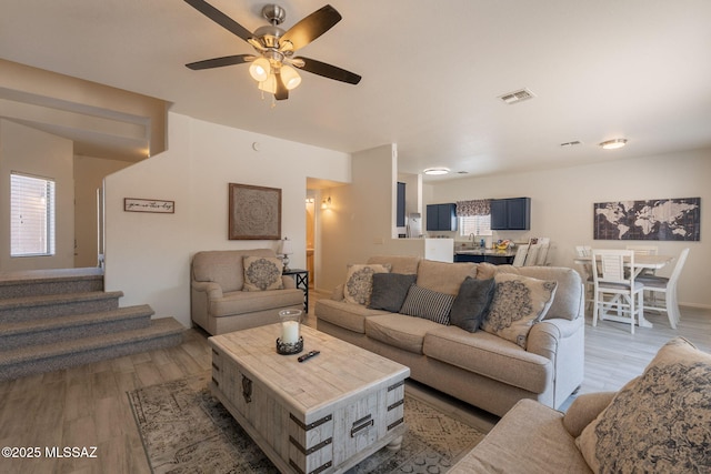 13218 E Mineta Ridge Dr, Vail, AZ 85641 - living area featuring light wood-style flooring, ceiling fan, and stairs