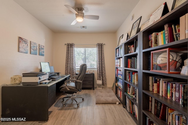 13218 E Mineta Ridge Dr, Vail, AZ 85641 - office space with light wood-style flooring, ceiling fan, and wall of books