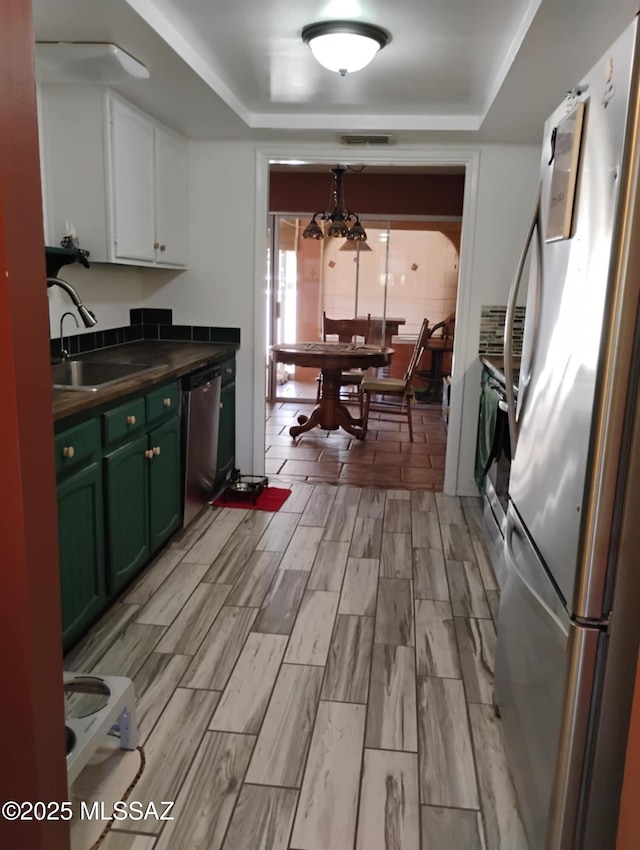 242 N Sage St, Pearce, AZ 85625 - kitchen with appliances with stainless steel finishes, green cabinets, dark countertops, and a raised ceiling