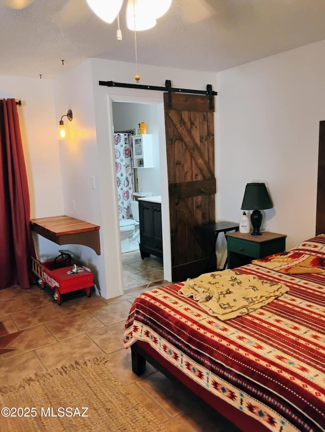 242 N Sage St, Pearce, AZ 85625 - tiled bedroom with a barn door, ensuite bathroom, and a ceiling fan