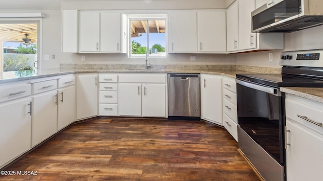 5701 E Waverly St, Tucson, AZ 85712 - kitchen featuring appliances with stainless steel finishes, a sink, dark wood-type flooring, and white cabinets