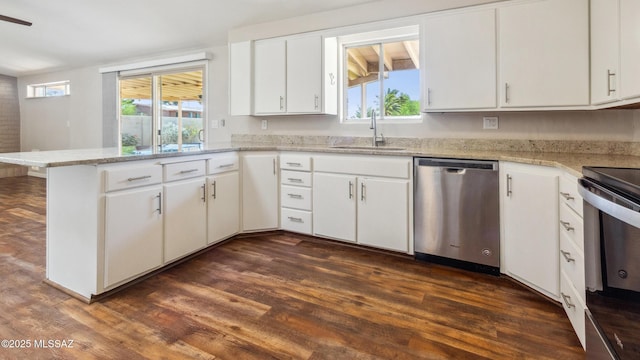 5701 E Waverly St, Tucson, AZ 85712 - kitchen with stainless steel appliances, a sink, a peninsula, dark wood-style flooring, and white cabinetry