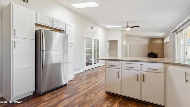 5701 E Waverly St, Tucson, AZ 85712 - kitchen with freestanding refrigerator, dark wood-style floors, ceiling fan, and white cabinets