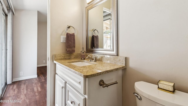 5701 E Waverly St, Tucson, AZ 85712 - bathroom featuring vanity, wood finished floors, toilet, and baseboards