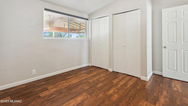 5701 E Waverly St, Tucson, AZ 85712 - unfurnished bedroom featuring two closets, vaulted ceiling, wood finished floors, and baseboards
