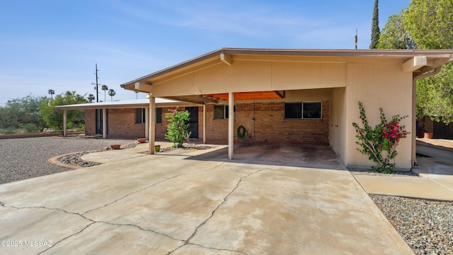 5701 E Waverly St, Tucson, AZ 85712 - view of front of home featuring a carport, driveway, and brick siding