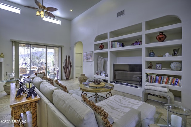 2460 N Cavalry Trl, Tucson, AZ 85749 - living area with built in features, arched walkways, ceiling fan, tile patterned flooring, and high vaulted ceiling