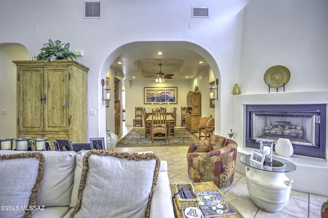 2460 N Cavalry Trl, Tucson, AZ 85749 - living area featuring arched walkways, a ceiling fan, light tile patterned floors, a fireplace, and recessed lighting