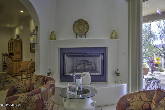 2460 N Cavalry Trl, Tucson, AZ 85749 - tiled living area with a fireplace with raised hearth, arched walkways, and recessed lighting