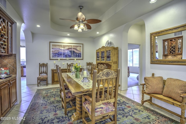 2460 N Cavalry Trl, Tucson, AZ 85749 - dining area with arched walkways, light tile patterned floors, a ceiling fan, recessed lighting, and a tray ceiling
