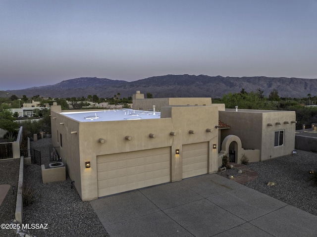 2460 N Cavalry Trl, Tucson, AZ 85749 - pueblo-style house featuring stucco siding, a mountain view, and an attached garage