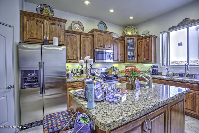 2460 N Cavalry Trl, Tucson, AZ 85749 - kitchen with appliances with stainless steel finishes, a sink, light tile patterned floors, stone countertops, and glass insert cabinets