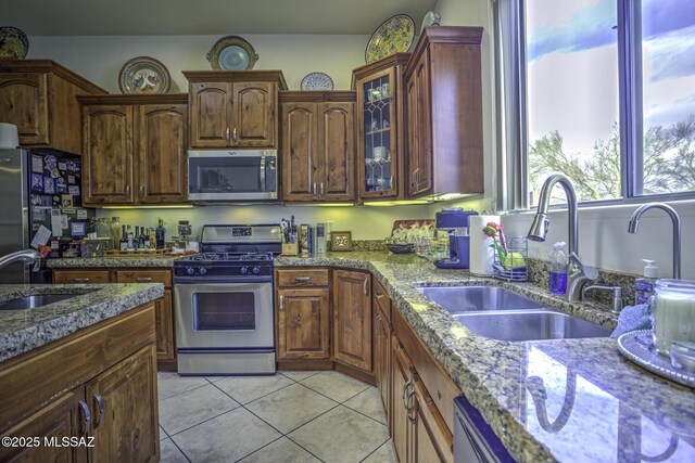 2460 N Cavalry Trl, Tucson, AZ 85749 - kitchen with appliances with stainless steel finishes, a sink, light tile patterned floors, and light stone countertops