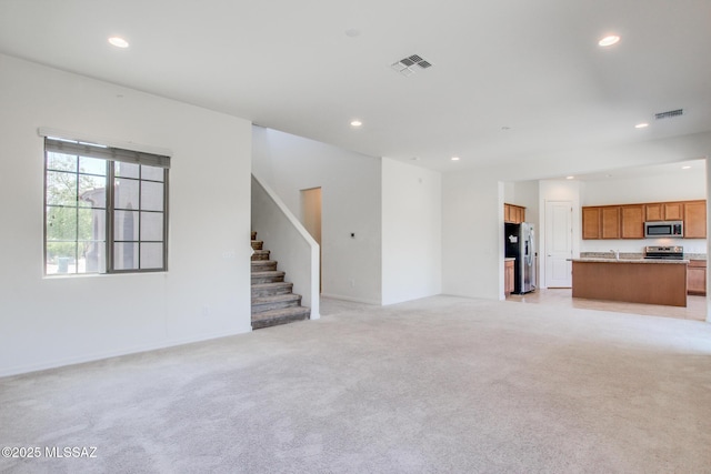 13391 N Flaxleaf Pl, Oro Valley, AZ 85755 - unfurnished living room with recessed lighting, light colored carpet, stairway, and baseboards