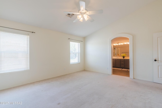 6805 W Tombstone Way, Tucson, AZ 85743 - unfurnished bedroom with arched walkways, light colored carpet, lofted ceiling, connected bathroom, and ceiling fan