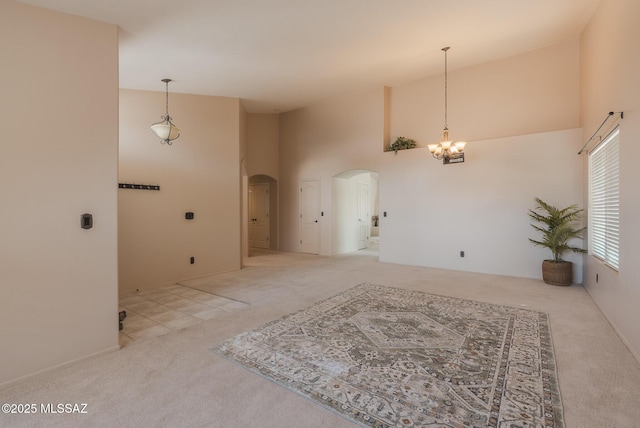 6805 W Tombstone Way, Tucson, AZ 85743 - carpeted spare room featuring arched walkways, a towering ceiling, and a chandelier