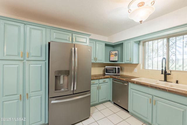 2501 W Calle Paraiso, Tucson, AZ 85745 - kitchen with stainless steel appliances, a sink, light tile patterned flooring, tile counters, and tasteful backsplash