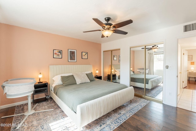 2501 W Calle Paraiso, Tucson, AZ 85745 - bedroom featuring two closets, wood finished floors, a ceiling fan, and baseboards