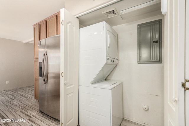 318 N Hasman Dr, Tucson, AZ 85745 - laundry area with estacked washer and dryer, electric panel, and light wood-type flooring