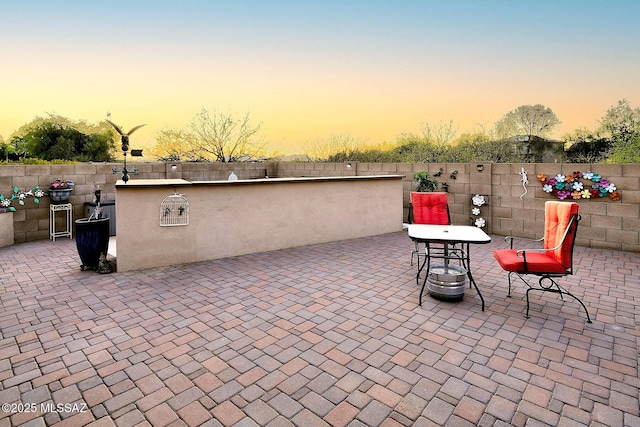 4795 E Silverpuffs Way, Tucson, AZ 85756 - patio terrace at dusk featuring a patio area