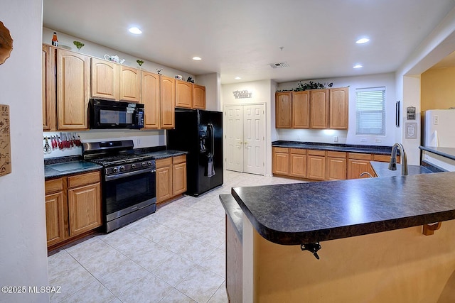 4795 E Silverpuffs Way, Tucson, AZ 85756 - kitchen with black appliances, dark countertops, a breakfast bar area, light tile patterned flooring, and recessed lighting