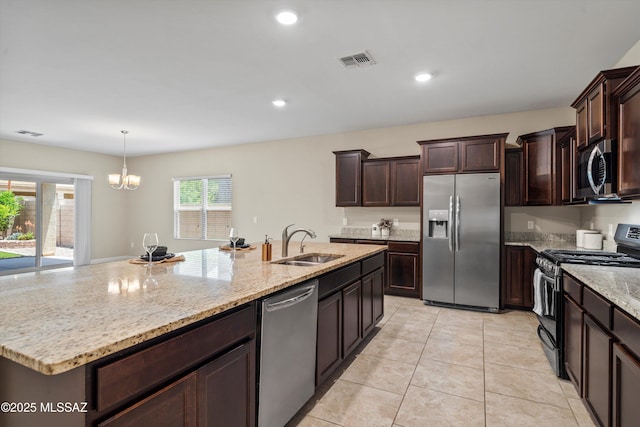 12223 E Becker Dr, Vail, AZ 85641 - kitchen with stainless steel appliances, a sink, a chandelier, light stone countertops, and dark brown cabinets