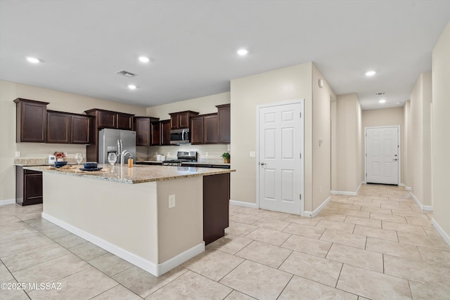 12223 E Becker Dr, Vail, AZ 85641 - kitchen with appliances with stainless steel finishes, dark brown cabinets, light stone countertops, an island with sink, and recessed lighting