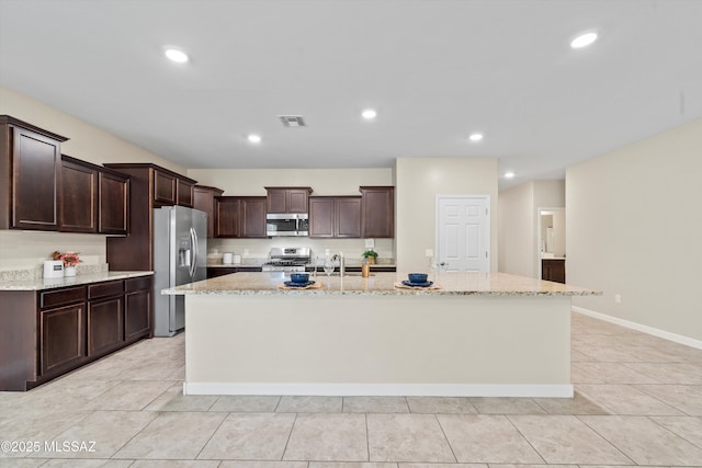 12223 E Becker Dr, Vail, AZ 85641 - kitchen featuring stainless steel appliances, a sink, dark brown cabinetry, a spacious island, and light stone counters