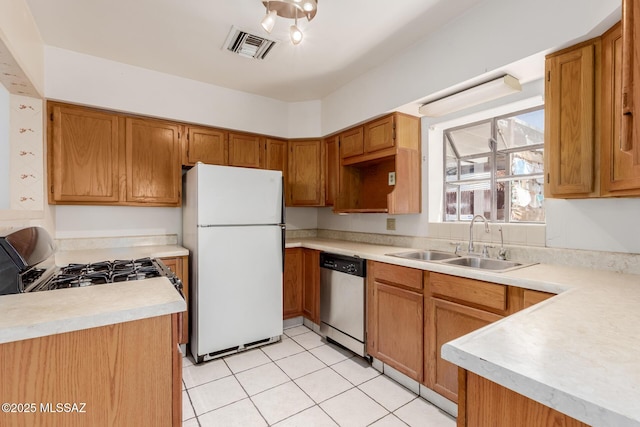 1026 E Mitchell St, Tucson, AZ 85719 - kitchen featuring stainless steel dishwasher, freestanding refrigerator, a sink, range with gas cooktop, and light countertops