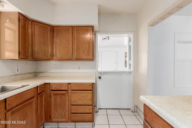 1026 E Mitchell St, Tucson, AZ 85719 - kitchen with light countertops, brown cabinets, and light tile patterned floors