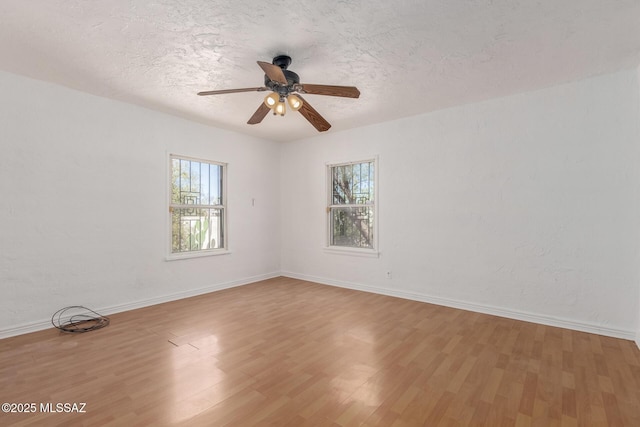 1026 E Mitchell St, Tucson, AZ 85719 - unfurnished room featuring healthy amount of natural light, wood finished floors, a ceiling fan, baseboards, and a textured ceiling