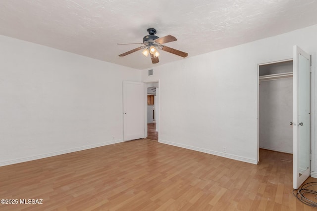 1026 E Mitchell St, Tucson, AZ 85719 - unfurnished bedroom featuring light wood-style floors, a closet, baseboards, a ceiling fan, and a spacious closet