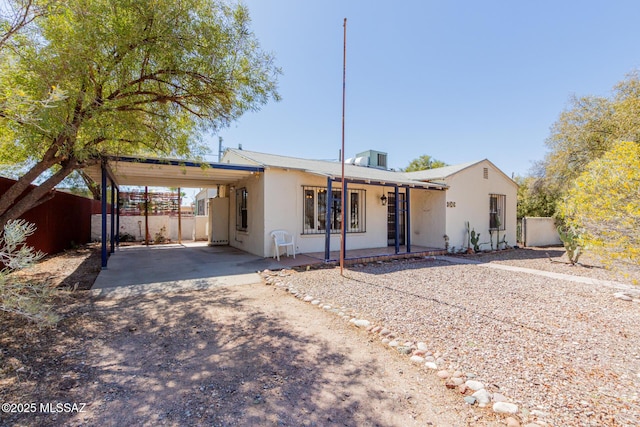 1026 E Mitchell St, Tucson, AZ 85719 - view of front of house featuring an attached carport, stucco siding, and dirt driveway