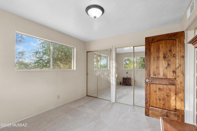 365 E Parkside St, Oracle, AZ 85623 - unfurnished bedroom featuring two closets, light carpet, and baseboards