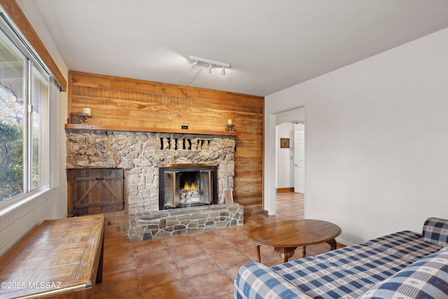 365 E Parkside St, Oracle, AZ 85623 - living area featuring wood walls, tile patterned flooring, rail lighting, a stone fireplace, and arched walkways