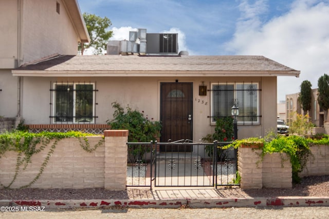 1238 S Camino Seco, Tucson, AZ 85710 - view of front of home featuring a fenced front yard, stucco siding, and cooling unit