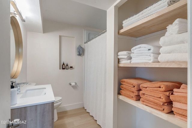 5762 E Helen St, Tucson, AZ 85712 - full bathroom with toilet, wood finished floors, vanity, baseboards, and curtained shower
