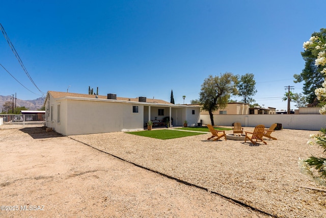 5762 E Helen St, Tucson, AZ 85712 - rear view of house featuring an outdoor fire pit, a fenced backyard, a patio area, and a mountain view