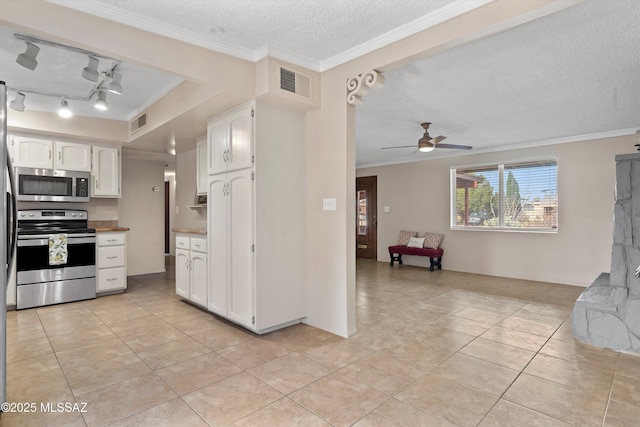 1709 S Avenida Sirio, Tucson, AZ 85710 - kitchen featuring appliances with stainless steel finishes, light tile patterned floors, white cabinetry, a textured ceiling, and ornamental molding