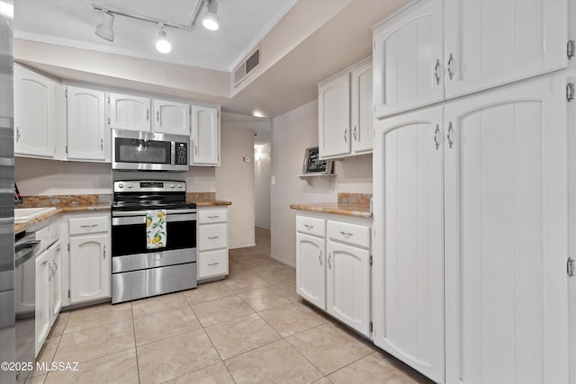 1709 S Avenida Sirio, Tucson, AZ 85710 - kitchen featuring stainless steel appliances, white cabinets, light tile patterned floors, and rail lighting