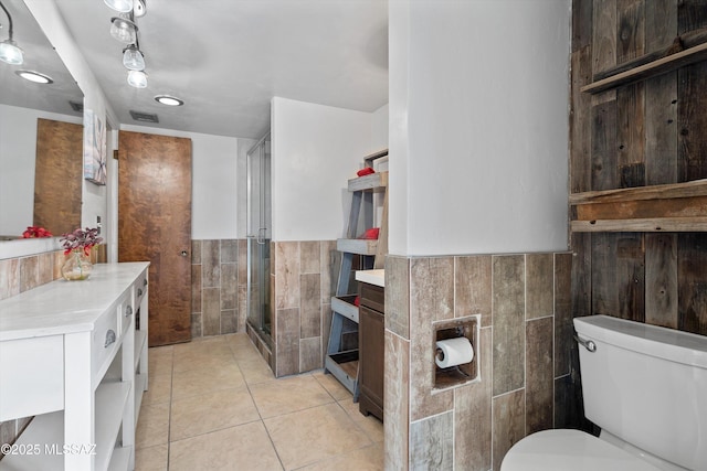 1709 S Avenida Sirio, Tucson, AZ 85710 - bathroom featuring tile walls, a stall shower, tile patterned flooring, toilet, and vanity