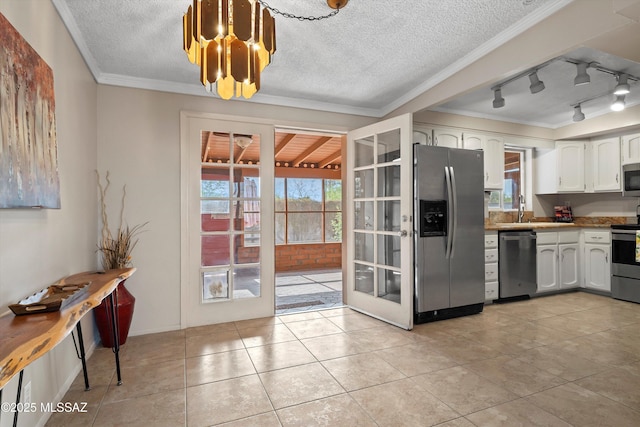 1709 S Avenida Sirio, Tucson, AZ 85710 - kitchen with appliances with stainless steel finishes, white cabinetry, crown molding, a textured ceiling, and a chandelier
